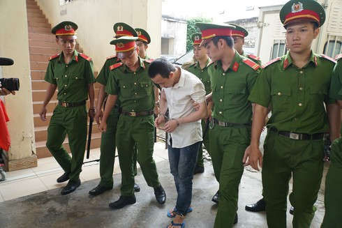 Bị cáo cúi gằm mặt khi bị dẫn giải ra tòa