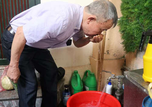 Ông Đinh Tiến Dũng - Bí thư chi bộ cụm cơ khí 1A, Khương Đình, Thanh Xuân kiểm tra mùi nước sáng 12/10. Ảnh: Võ Hải.