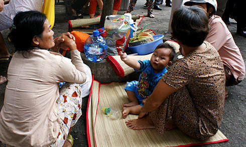 Bệnh nhi nằm bên gốc cây tại Bệnh viện Nhi đồng 1 trong chuyến thị sát của Bộ trưởng Y tế ngày 28/11/2011. Ảnh: Thiên Chương.