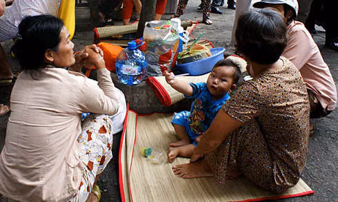 Bệnh nhi nằm bên gốc cây tại Bệnh viện Nhi đồng 1 trong chuyến thị sát của Bộ trưởng Y tế ngày 28/11/2011. Ảnh: Thiên Chương.