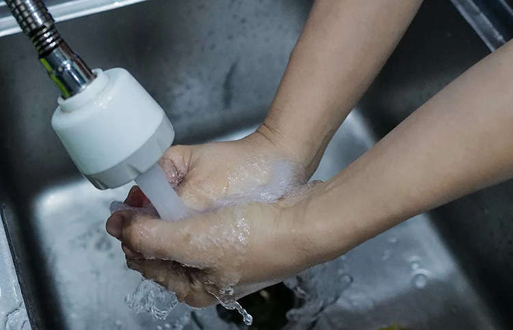 Người dân Chung cư HH Linh Đàm thử mùi nước từ vòi. Ảnh: Ngọc Thành.