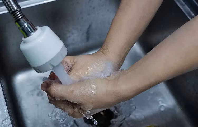 Người dân Chung cư HH Linh Đàm thử mùi nước từ vòi. Ảnh: Ngọc Thành.