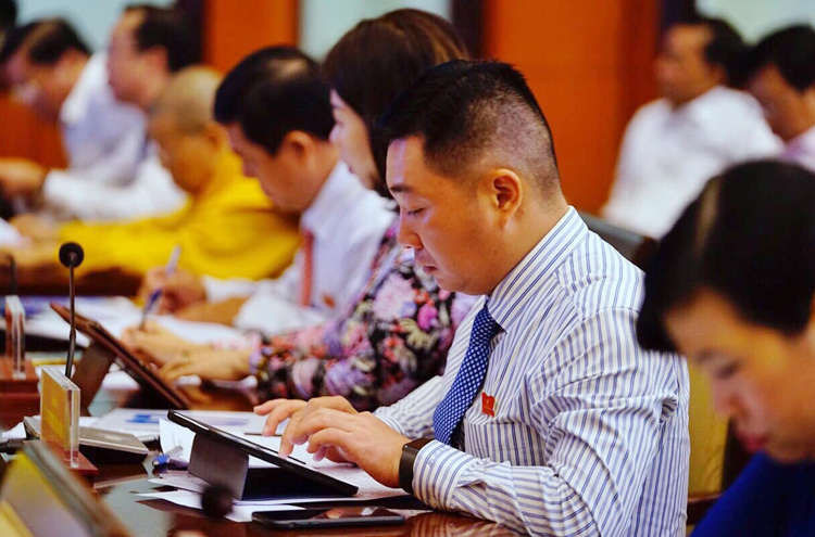 Đại biểu HĐND TP HCM xem tài liệu kỳ họp. Ảnh: Trung Sơn.