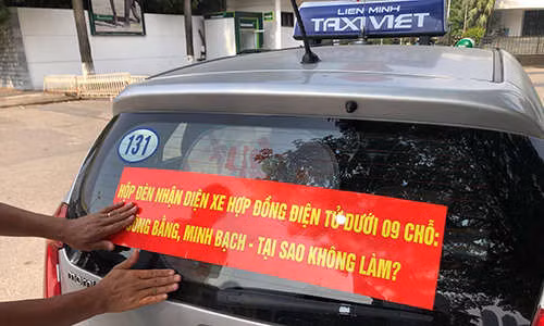Chiều hãng taxi truyền thống lại dán khẩu hiệu yêu cầu taxi công nghệ gắn mào. Ảnh: Anh Tú