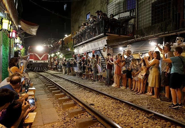 Du khách chụp ảnh đoàn tàu trước khi khu vực xóm cà phê bị ngừng hoạt động. Ảnh: Giang Huy. 