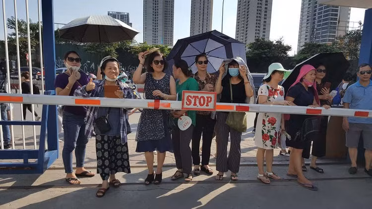 Phụ huynh đứng chờ con trong thời tiết nắng nóng gay gắt ở Hà Nội.