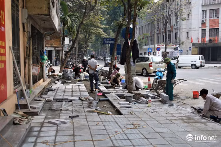Trong khi gần chục công nhân hì hục lật vỉa hè lên lát lại thì hoạt động buôn bán trên vỉa hè vẫn diễn ra bình thường.