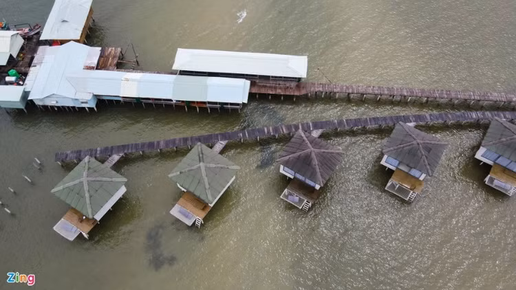 Tại đây, 17 bungalow, 3 cây cầu dẫn, 1 khu quán ăn, 1 khu nuôi cá bè, 1 quầy bar vẫn hiện hữu dù quyết định buộc tháo dỡ đã có hiệu lực. (Ảnh: Zing).