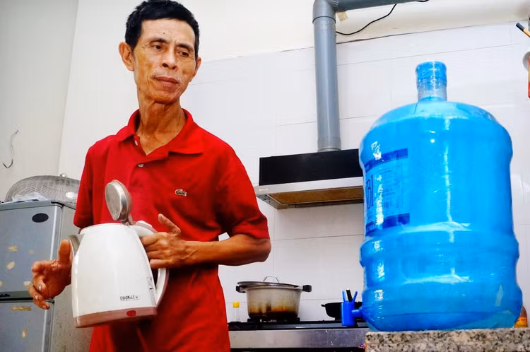 Ông Trần Văn Huy (66 tuổi) phải mua nước bình về dùng.
