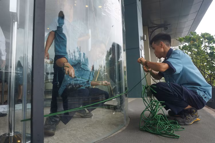 Nhân viên các tòa nhà khẩn trương chằng buộc bảo vệ cửa kính ngay trong chiều 18/9. Nhân viên các tòa nhà khẩn trương chằng buộc bảo vệ cửa kính ngay trong chiều 18/9.
