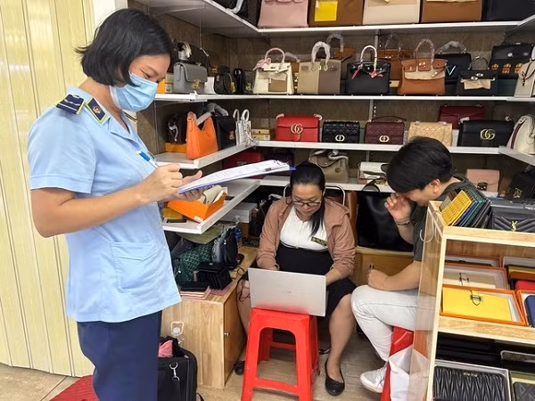 Lực lượng quản lý thị trường TP HCM kiểm tra và thu giữ nhiều sản phẩm giả, nhái tại Trung tâm thương mại Saigon Square. Nguồn: QLTT