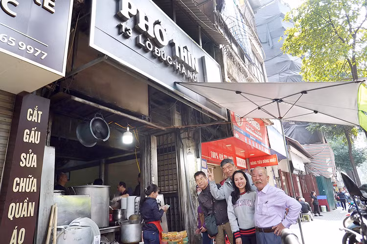 Ông Thìn chụp ảnh chung cùng các thực khách nước ngoài.