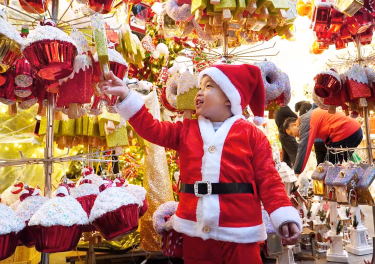 Bé Chuối, Đặng Minh Quân, 3 tuổi rất thích thú với những món đồ chơi tại phố Hàng Mã (Hoàn Kiếm, Hà Nội).