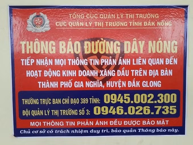 Cục Quản lý thị trường tỉnh Đắk Nông tuyên truyền, dán tờ rơi cung cấp số điện thoại đường dây nóng.