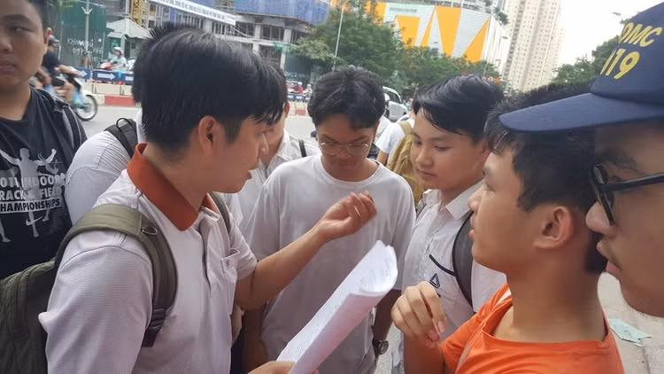 Thầy Võ Quốc Bá Cẩn đưa học sinh thi vào lớp 10 tại điểm thi Trường THPT chuyên Amsterdam, Hà Nội, chờ các em kết thúc môn thi rồi cùng học trò rà lại đáp án - Ảnh: Mai Nguyễn.