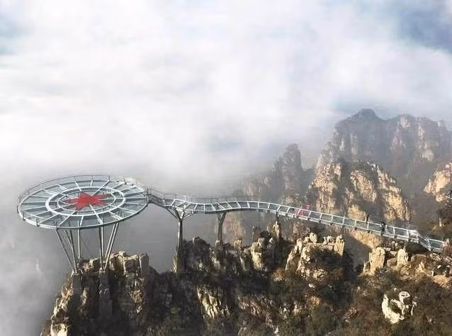 Cây cầu nằm ở độ cao 450m thuộc vùng núi Lang Nha, tỉnh Hồ Bắc. Toàn bộ kiến trúc độc đáo này gồm một lối đi và một đài quan sát hình tròn hoàn toàn bằng kính trong suốt, với tổng diện tích hơn 460m2 và sức chứa hơn 200 người. Điểm độc đáo của cây cầu chính là nằm hẳn trên đỉnh núi. Để đến được chiếc cầu này, du khách có thể đi bộ lên trên núi hoặc đi cáp treo. Ảnh dulichbenvung Cây cầu nằm ở độ cao 450m thuộc vùng núi Lang Nha, tỉnh Hồ Bắc. Toàn bộ kiến trúc độc đáo này gồm một lối đi và một đài quan sát hình tròn hoàn toàn bằng kính trong suốt, với tổng diện tích hơn 460m2 và sức chứa hơn 200 người. Điểm độc đáo của cây cầu chính là nằm hẳn trên đỉnh núi. Để đến được chiếc cầu này, du khách có thể đi bộ lên trên núi hoặc đi cáp treo. Ảnh dulichbenvung