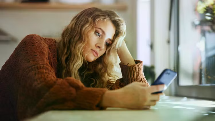 sad-young-adult-female-smartphone-stare.jpg