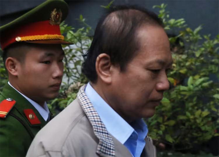 Cựu bộ trưởng Trương Minh Tuấn bị dẫn giải vào phòng xét xử. Ảnh: Phạm Dự