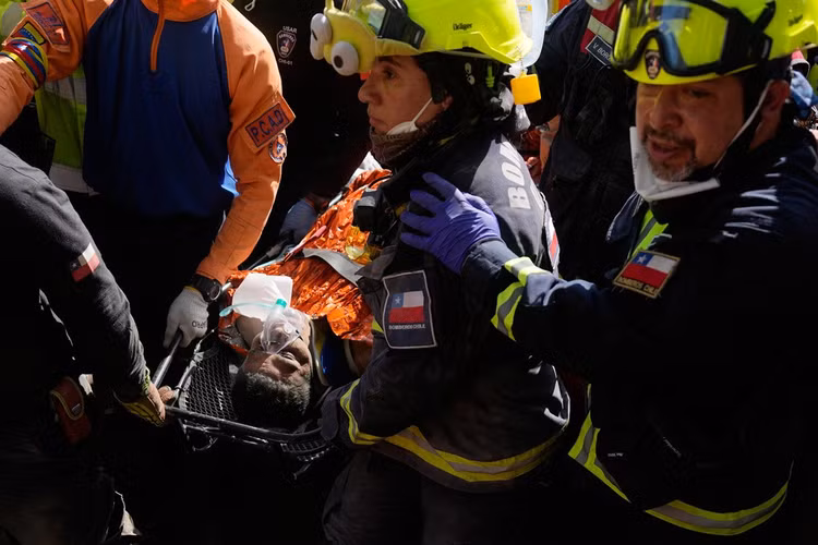 Các nhân viên cứu hộ Chile đưa Hernán Alberto Gil Flores ra ngoài hôm 2/7/2026 sau khi ông mắc kẹt 8 ngày sau khi bị mắc kẹt bởi hai trận động đất liên tiếp xảy ra ở Catia La Mar, Venezuela. Ảnh: AP/Fernando Vergara.