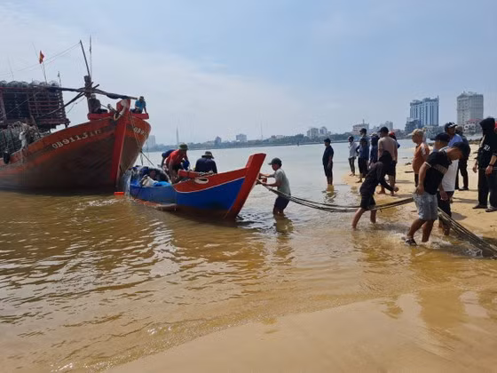 Lực lượng chức năng cùng người dân trục vớt, lai dắt thuyền của ông Phong vào bờ. Lực lượng chức năng cùng người dân trục vớt, lai dắt thuyền của ông Phong vào bờ.