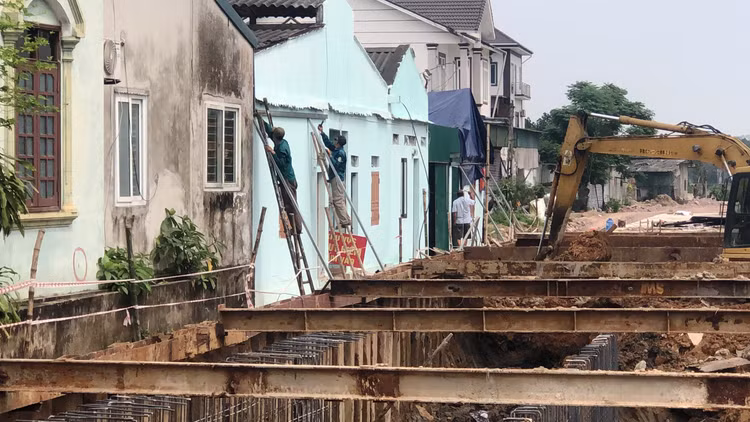 Công nhân đang dựng sắt hộp chằng chống tường nhà gia đình ông Chiến để tránh đổ sập.