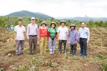 Bệnh binh A Thắm (mặc áo mưa tím) thỏa ước nguyện trồng 1000 cây cà phê giống.