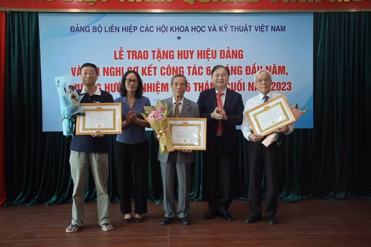 TSKH Phan Xuân Dũng và bà Hà Thị Trang trao tặng Huy hiệu Đảng cho các Đảng viên