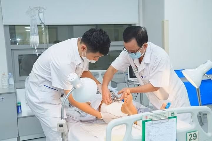 Bệnh nhân được chăm sóc sau ca phẫu thuật nối hai cẳng chân bị đứt rời - Ảnh: An ninh Thủ đô