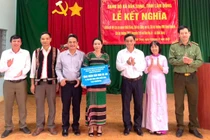 Đồng chí Phó Bí thư Thường trực Đảng ủy xã và đại diện các chi bộ trao tặng quà cho Nhân dân bon Bu Jri.