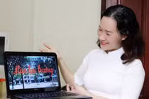 Cô giáo mặc áo dài, ngồi tại nhà dự lễ khai giảng online, khởi đầu một năm học đặc biệt.