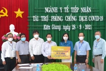 Đại diện Tập đoàn Sun Group (áo xanh) trao bảng tượng trưng hỗ trợ lãnh đạo Sở Y tế Kiên Giang.
