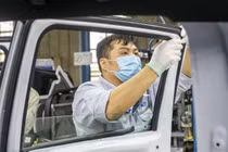 Công nhân lắp cửa kính lên xe bán tải Ford Ranger tại nhà máy ở Hải Dương.