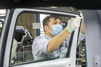 Công nhân lắp cửa kính lên xe bán tải Ford Ranger tại nhà máy ở Hải Dương.