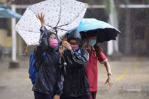 Thí sinh đến trường thi môn Toán trong cơn mưa