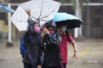 Thí sinh đến trường thi môn Toán trong cơn mưa