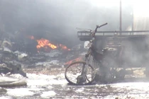 Bên trong bãi xe cháy có nhiều phương tiện gồm xe máy, xe ba gác máy, xe tải bị cháy, hư hỏng