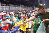 Công an phát thức ăn va nước uống cho người dân tự ý về quê. Ảnh: Tiến Tầm.