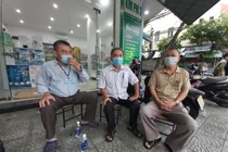 Tổ trưởng Tổ dân phố 35 và Bí thư Chi bộ khu dân cư Hoà Phú 5 cùng người dân trao đổi việc hỗ trợ quà. 