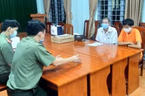 P.T. (áo cam) tại cơ quan công an.