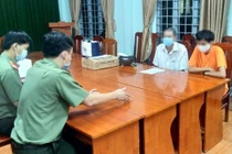 P.T. (áo cam) tại cơ quan công an.