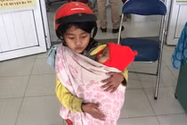 Xôn xao hình ảnh bé gái 7 tuổi bế em đi tiêm phòng