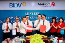 Ông Trần Long, Phó Tổng Giám đốc BIDV (bên phải) và ông Võ Quang Vinh, Phó Tổng Giám đốc Vietlott đại diện hai bên ký kết hợp đồng.