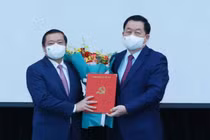 Ông Nguyễn Trọng Nghĩa trao quyết định và tặng hoa chúc mừng ông Lại Xuân Môn. 