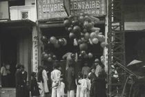 Trẻ em và người lớn bị thu hút bởi những trái bóng bay tại một cửa hàng ngày Tết.