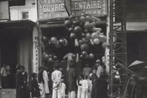 Trẻ em và người lớn bị thu hút bởi những trái bóng bay tại một cửa hàng ngày Tết.