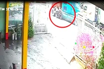 Khoảnh khắc hai vợ chồng đi xe máy va chạm với container (ảnh cắt từ clip). 