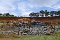 Xe múc đang đào, đục khoét đá tại khu vực mỏ thôn 13, xã Đắk Wer, huyện Đắk R'Lấp