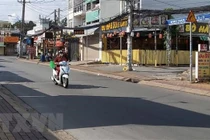 Người đi giao hàng cho các hộ dân theo khung giờ khu vực đường Đình Phong Phú, thành phố Thủ Đức, Thành phố Hồ Chí Minh. (Ảnh: Hồng Nhung/TTXVN)