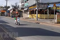 Người đi giao hàng cho các hộ dân theo khung giờ khu vực đường Đình Phong Phú, thành phố Thủ Đức, Thành phố Hồ Chí Minh. (Ảnh: Hồng Nhung/TTXVN)