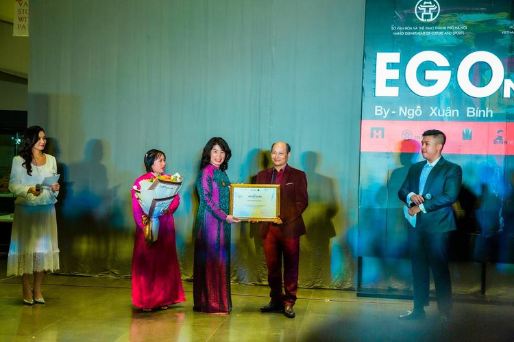 Bà Trần Vân Anh - Phó Giám đốc Sở Văn hóa và Thể thao thành phố Hà Nội trao chứng nhận cho họa sĩ Ngô Xuân Bính.